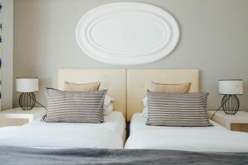 拉戈斯巴卢阿特达维拉公寓式酒店的一间卧室设有两张床、两盏灯和一个圆形天花板。
