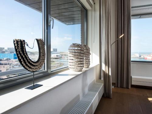 斯海弗宁恩Luxury apartment in the harbor of Scheveningen的一间设有窗户的房间,在树 ⁇ 上摆放着两个雕塑