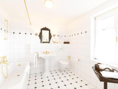 DettighofenHofgut Albführen的白色的浴室设有浴缸、盥洗盆和卫生间。
