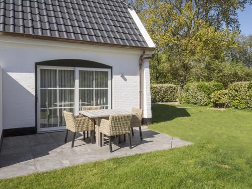 德科克斯多普Apartment in tasteful farmhouse in De Cocksdorp on the Wadden island of Texel的庭院里配有桌椅