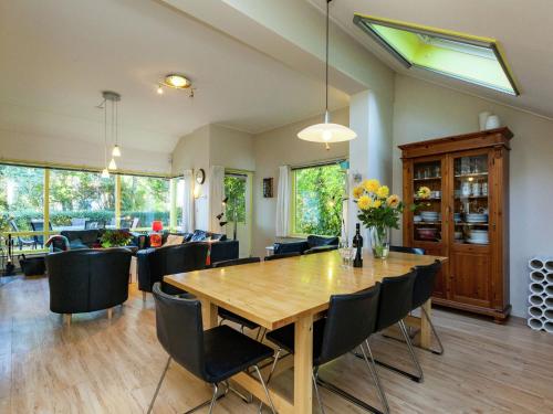 迪斯胡克Charming Holiday Home in Koudekerke Dishoek的一间带木桌和椅子的用餐室