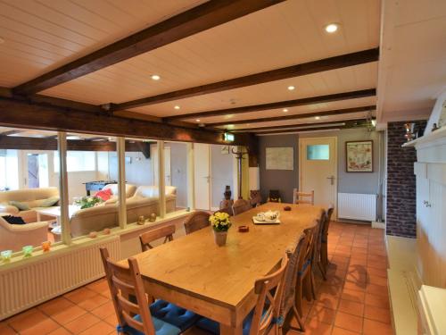 莱尔丹Quaint Farmhouse near River in Oosterwijk的用餐室配有大型木桌和椅子