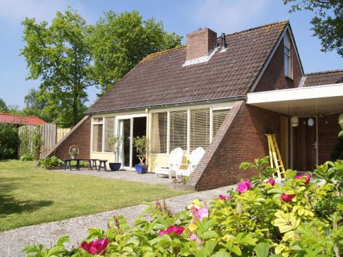 劳雷尔苏格Cosy holiday home in Lauwersoog的砖屋,带庭院和鲜花