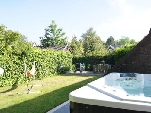 劳雷尔苏格Cosy holiday home in Lauwersoog的后院的热水浴池,后院的院子,有院子
