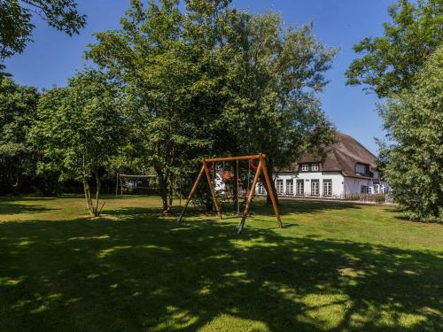 德科克斯多普Apartment in farmhouse on the island of Texel的庭院内的秋千和房子