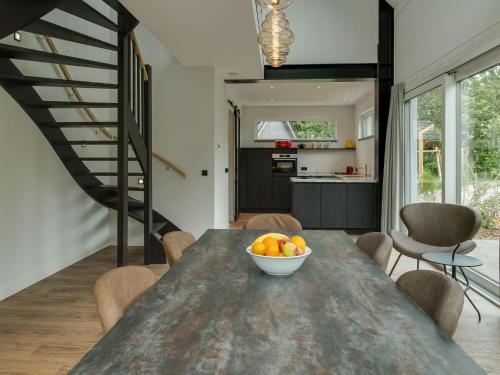 WestermientHoliday home on island Texel with sauna的厨房以及带一碗水果的桌子的用餐室。