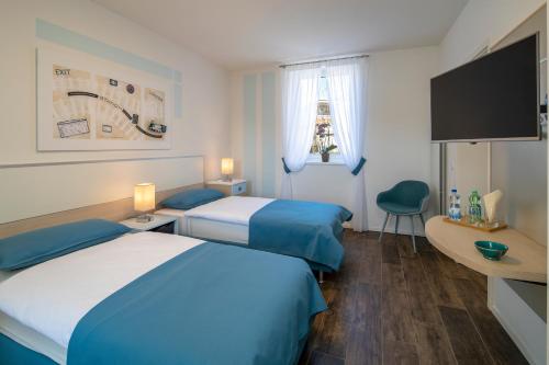 BalernaAlbergo Ristorante Stazione Balerna的酒店客房设有两张床和一台平面电视。