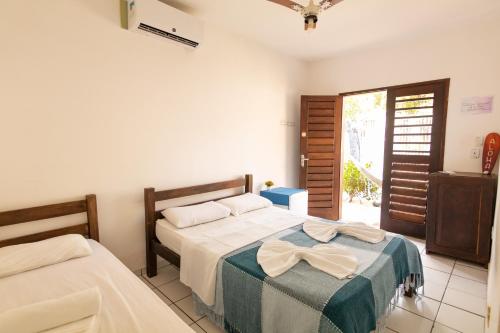 皮帕Surfcamp Arara的一间卧室设有两张床,并设有一个通往庭院的门。