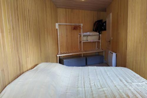 圣皮耶尔代勒福尔卡Appartement T3 en RDC 54 m2 avec balcon的一间卧室设有一张床和木墙