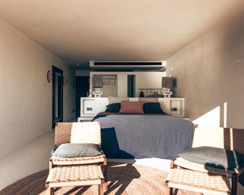 米乔尔海滩Casa Formentera的一间卧室配有一张床和两把椅子