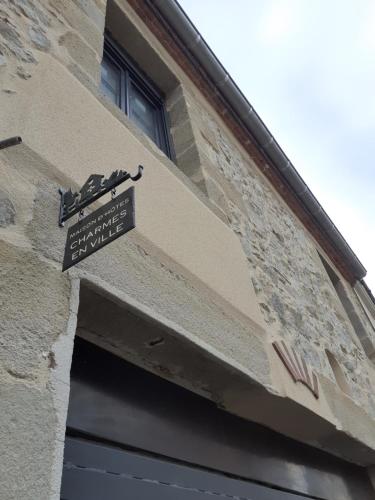 蒙吕松CHARMES EN VILLE Le Charme Atypique的门上标有标志的建筑物