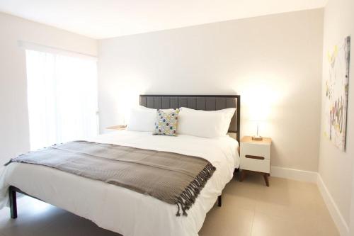 劳德代尔堡Designer River View Apartments的白色的卧室设有一张大床和一个窗户