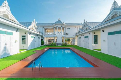 七岩Bianco House Resort的一座大房子,在庭院里设有一个游泳池