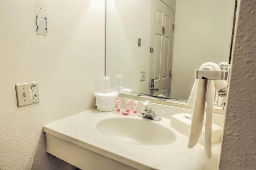 麦库克Coratel Inn & Suites by Jasper McCook的浴室设有白色水槽和镜子