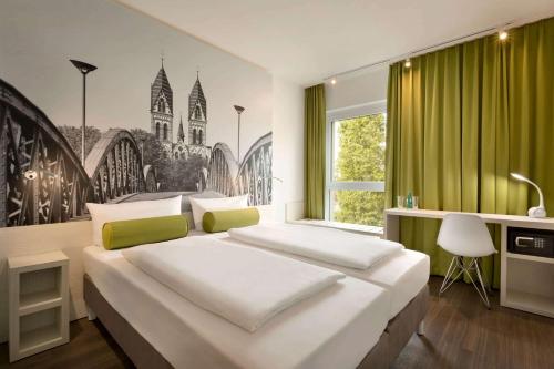 弗莱堡弗莱堡速8酒店的一间卧室配有一张带绿帘的大床