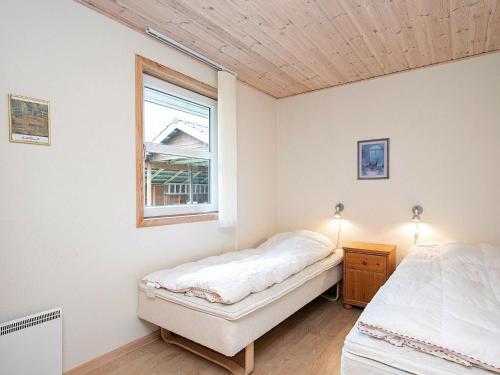 莱斯Holiday home Læsø XXIV的一间卧室设有两张床和窗户。