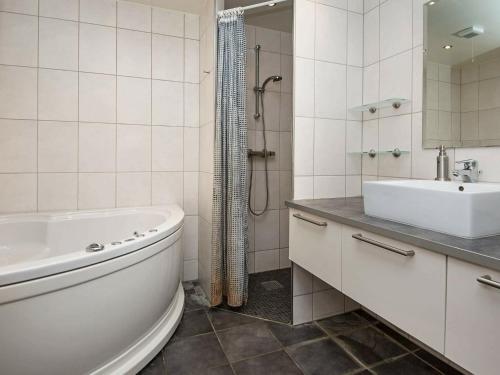 孔斯马克Three-Bedroom Holiday home in Rømø 5的白色的浴室设有浴缸和水槽。
