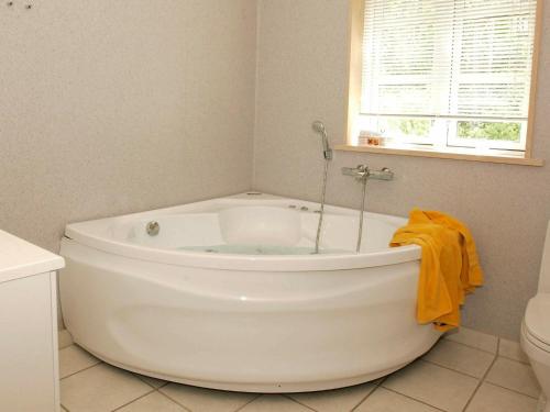 维斯特索马肯10 person holiday home in Aakirkeby的带窗户的浴室内的白色浴缸