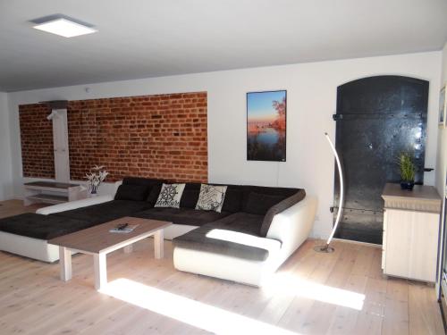 巴特Speicher Residenz Barth E4 App 9的带沙发和砖墙的客厅