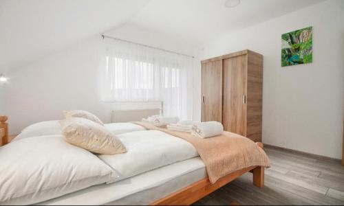 塞里特雷尼科Apartment Josipa的卧室配有一张带白色床单和枕头的大床。