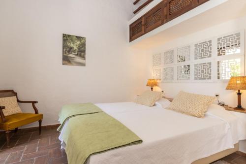 塔维拉奎塔多卡拉科尔酒店的卧室配有白色的床和黄色椅子