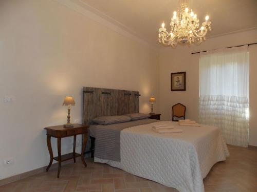 MarcoianoLa Casetta的一间卧室配有一张床和一个吊灯