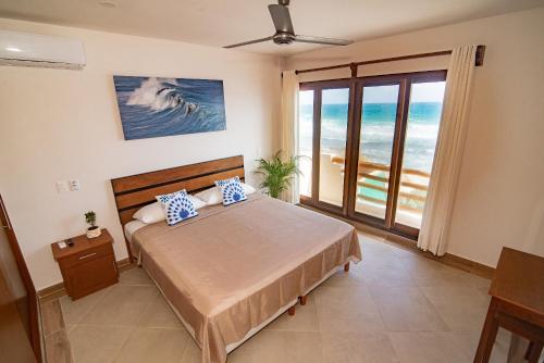 女人岛Villas Najo' Isla Mujeres.的一间卧室设有一张床,享有海景