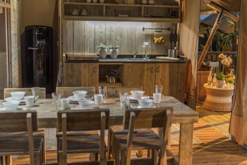 奥茨塞巴德·迪尔哈根Frei wie der Wind-Glamping的厨房配有带椅子和水槽的木桌