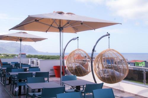 塔拉法尔Hotel Por Do Sol的一个带桌椅和遮阳伞的庭院