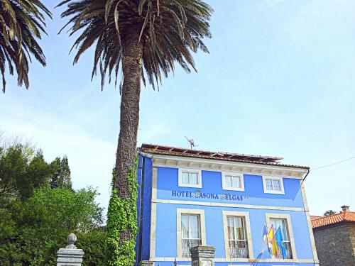 库迪列罗H Casona Selgas de Cudillero的一座蓝色的建筑,前面有棕榈树