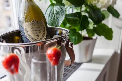 兰卡斯特兰卡斯特区酒店的草莓旁边的桶里一瓶香槟
