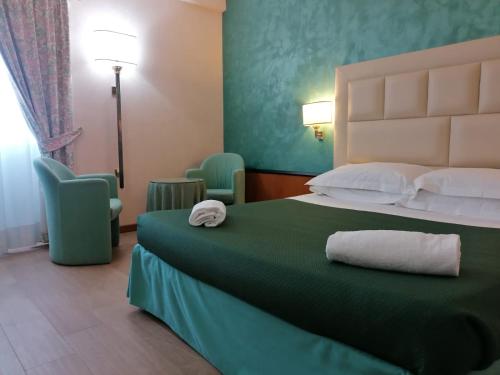波梅齐亚王子酒店的酒店客房,配有一张带绿床罩的床