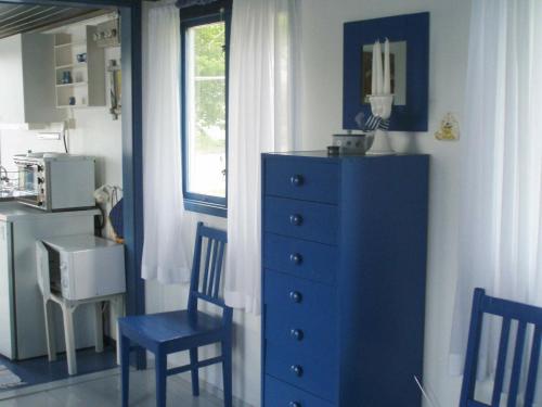 斯泰农松德One-Bedroom Holiday home in Stenungsund的一间设有蓝色梳妆台、两把椅子和窗户的房间