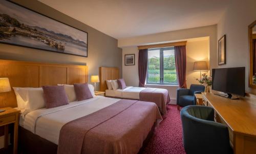 克利夫登克利夫登站酒店的酒店客房设有两张床、一张桌子和一台电视。