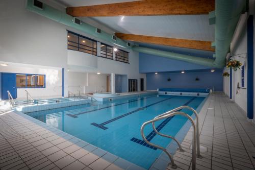 克利夫登克利夫登站酒店的一座拥有蓝色墙壁和木制天花板的大型游泳池