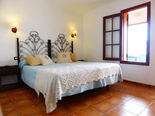 阿尔卡拉艾尔纳维奥乡村酒店-只接待成人的一间卧室配有一张带白色床单的床和一扇窗户。
