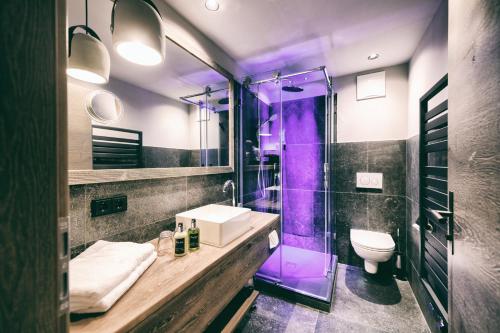 格罗萨尔Berg-Leben的浴室配有水槽和带紫色照明的淋浴