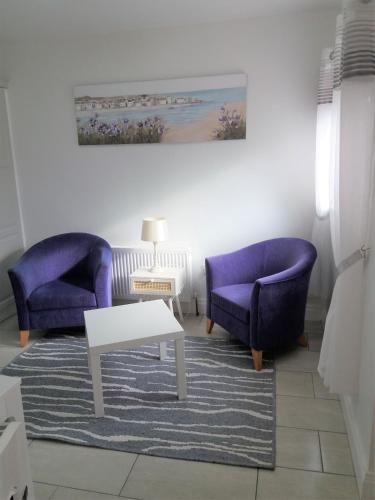 拉斯德拉姆Lettermore Apartment 2的客厅配有2把紫色椅子和1张桌子