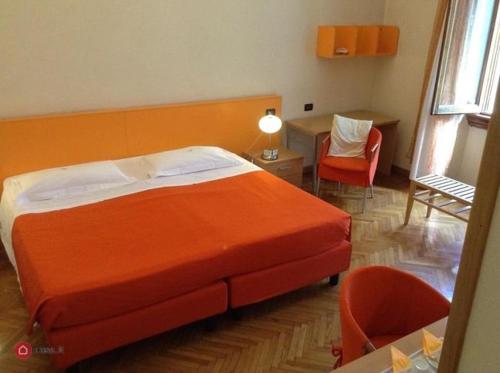普拉托Affittacamere ACCASA的一间卧室配有橙色的床和桌椅