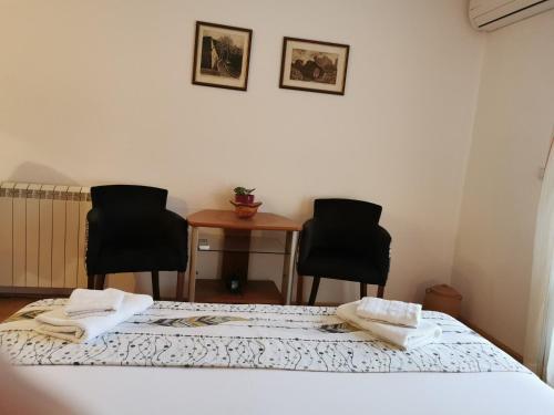 威尔帕扎Guesthouse Vukasevic的一间客房配有两张床和两把椅子