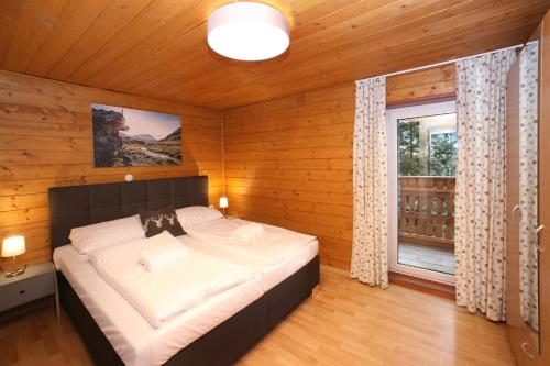 滨湖采尔雪绒花小木屋公寓的木制客房内的一间卧室配有一张大床