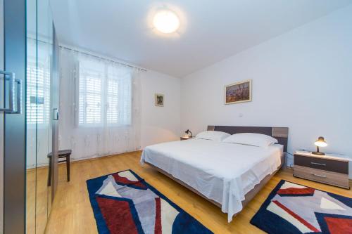 扎通Guest House Katica的一间白色的卧室,配有一张床和玻璃墙