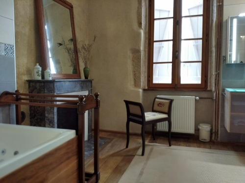 Cercy-la-TourChez Casimir的一间带椅子、浴缸和镜子的浴室