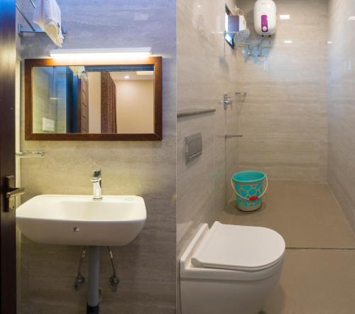 蓬蒂切里Pranaav Beach Resort的一间带卫生间、水槽和镜子的浴室