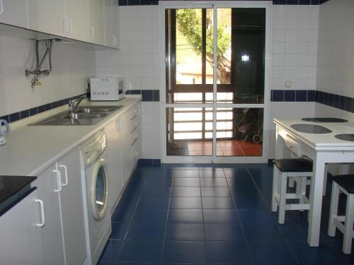 丰沙尔Apartamento Capela的厨房配有水槽和洗衣机