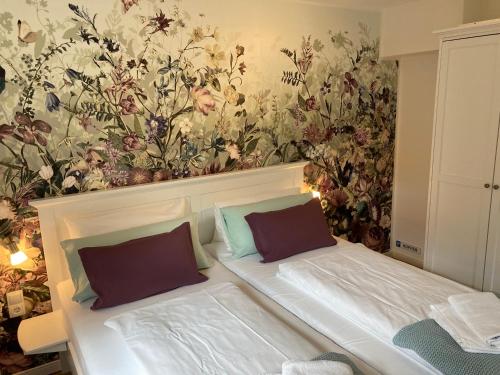 卑尔根Appartement 2 Garten的一间卧室配有一张带花卉壁纸的床