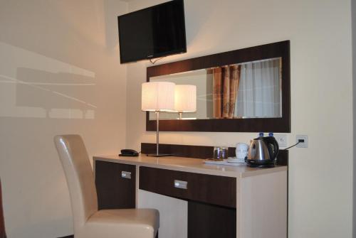 大谢尔皮亚Hotel Eljot的酒店客房配有带椅子和镜子的书桌