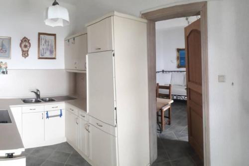 阿尔加拉斯蒂Ferienwohnung Castello Sebastian的厨房配有白色橱柜、水槽和冰箱。