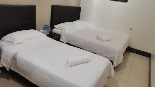吉隆坡LSN Hotel (KL) Sdn Bhd的配有白色床单的酒店客房内的两张床