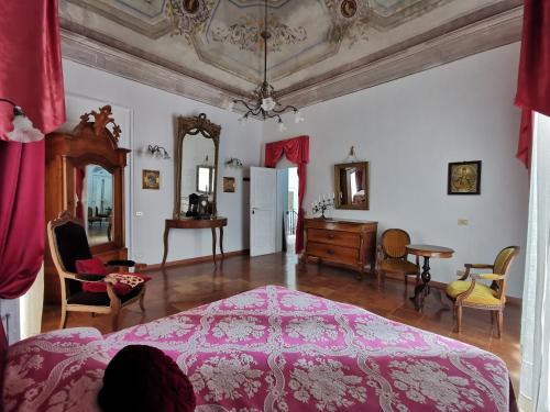 卢切拉爵床叶旅馆的卧室配有粉红色的床和桌椅